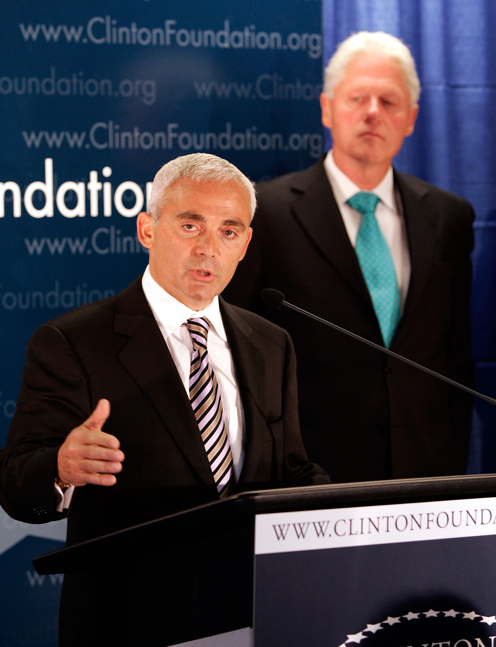 Frank Giustra speaks as former President Bill Clinton looks on during a press conference announcing the Clinton Giustra Sustainable Growth Initiative, New York, June 21, 2007