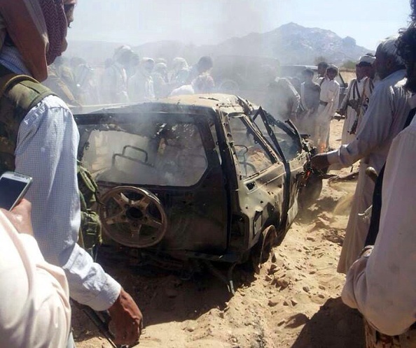 Yemenis gather around a burnt car after it was targeted by a drone strike, killing three suspected al-Qaeda militants, January 26, 2015 