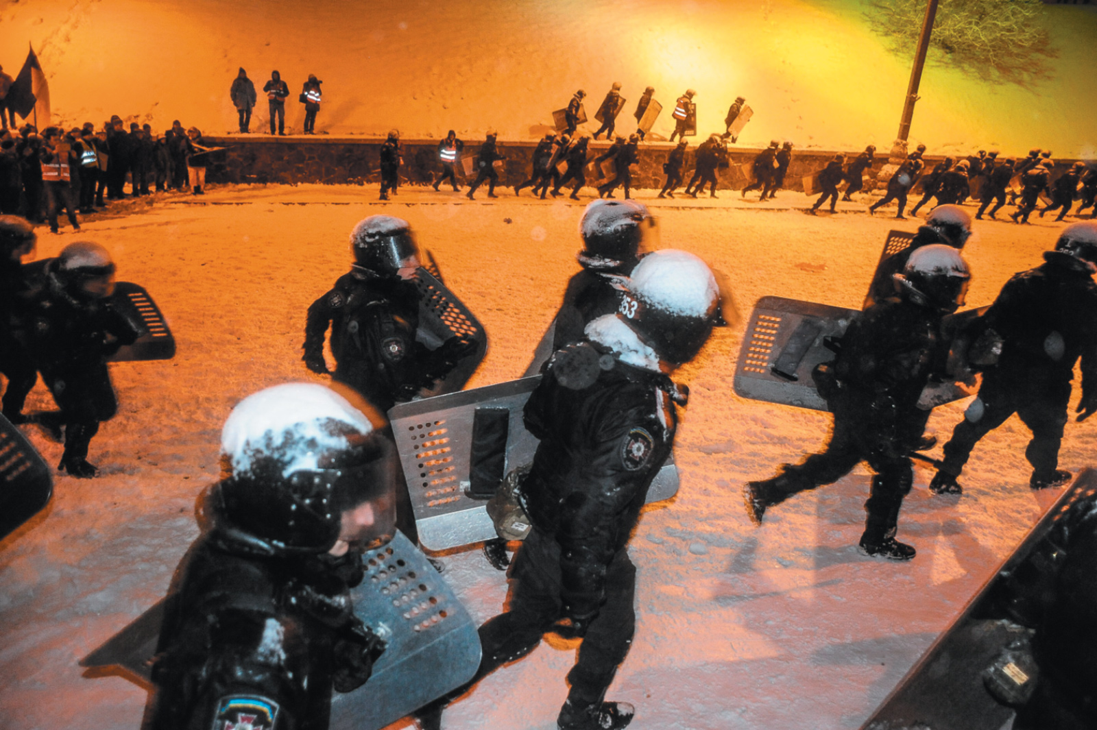Riot police retreating after trying to push back protesters near the Cabinet of Ministers building during the Maidan protests in Kiev, December 2013
