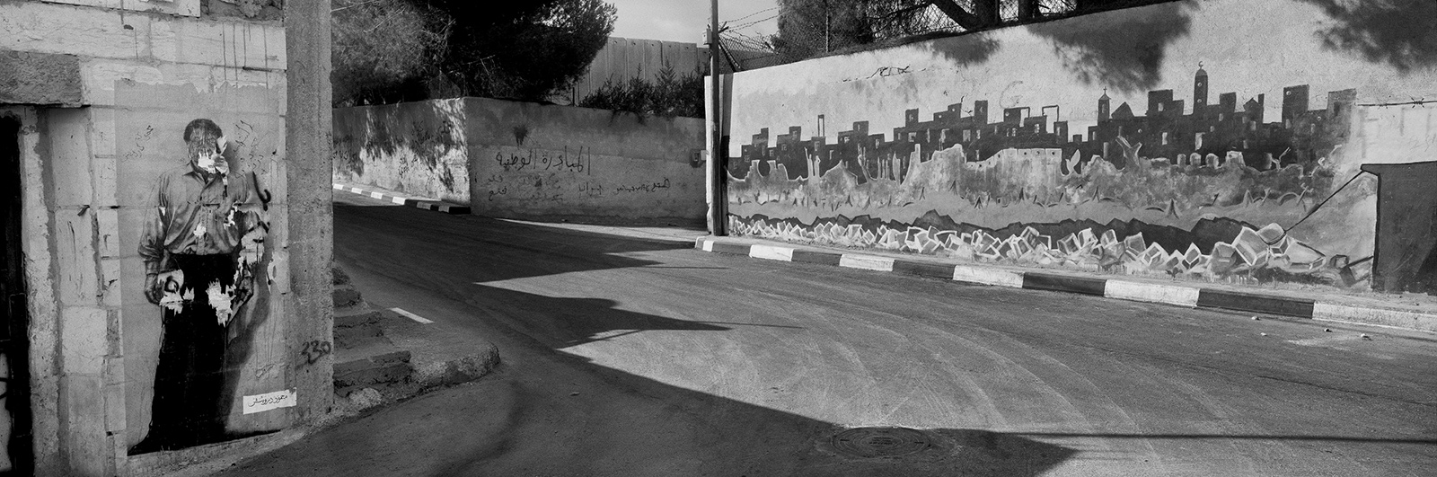 A poster of the Palestinian poet Mahmoud Darwish (left), Aida refugee camp, near Bethlehem, West Bank, 2009; photograph by Josef Koudelka from ‘This Place,’ an exhibition of pictures by twelve photographers of Israel and the West Bank, at the Brooklyn Museum of Art until June 5, 2016