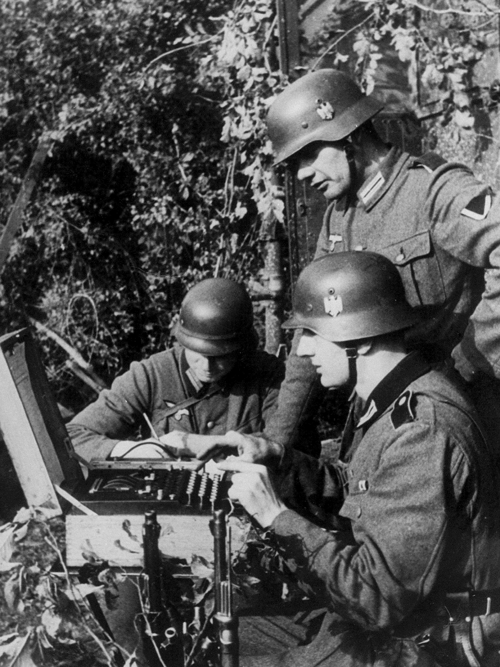 German soldiers in the field enciphering a message on the Enigma code machine, circa 1940
