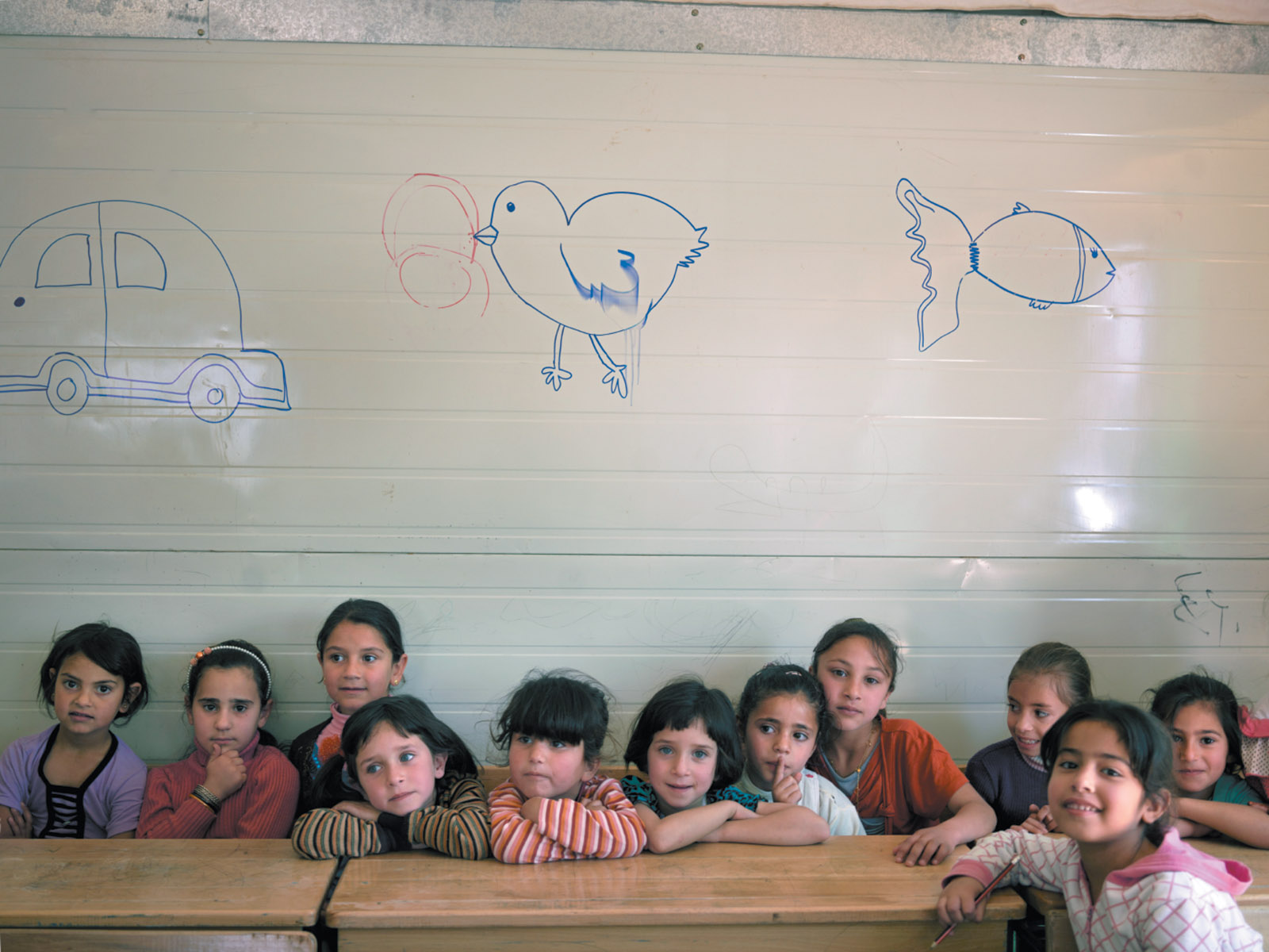 Syrian children at a school in the Zaatari refugee camp, near Mafraq, Jordan, April 2016. Several members of the staff receive pay through UNICEF’s cash-for-work program, managed by the United Nations Office for Project Services.