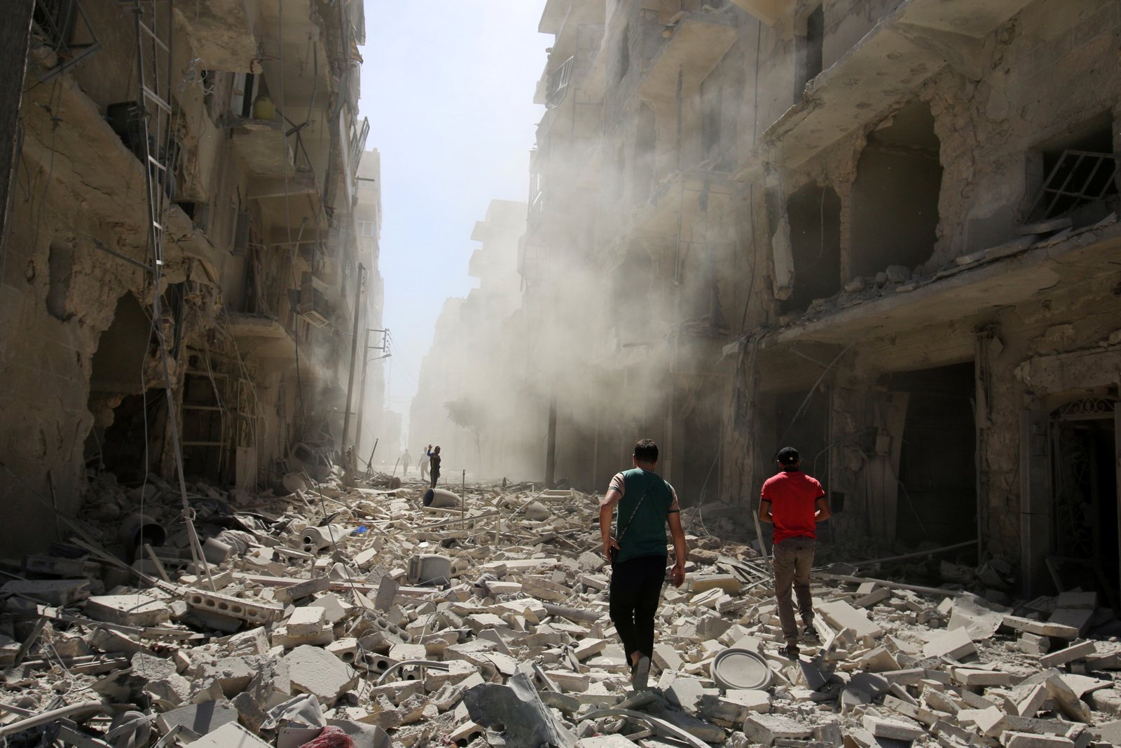 Syrians inspecting the damage after an air strike on the al-Qaterji neighborhood of Aleppo, September 2016