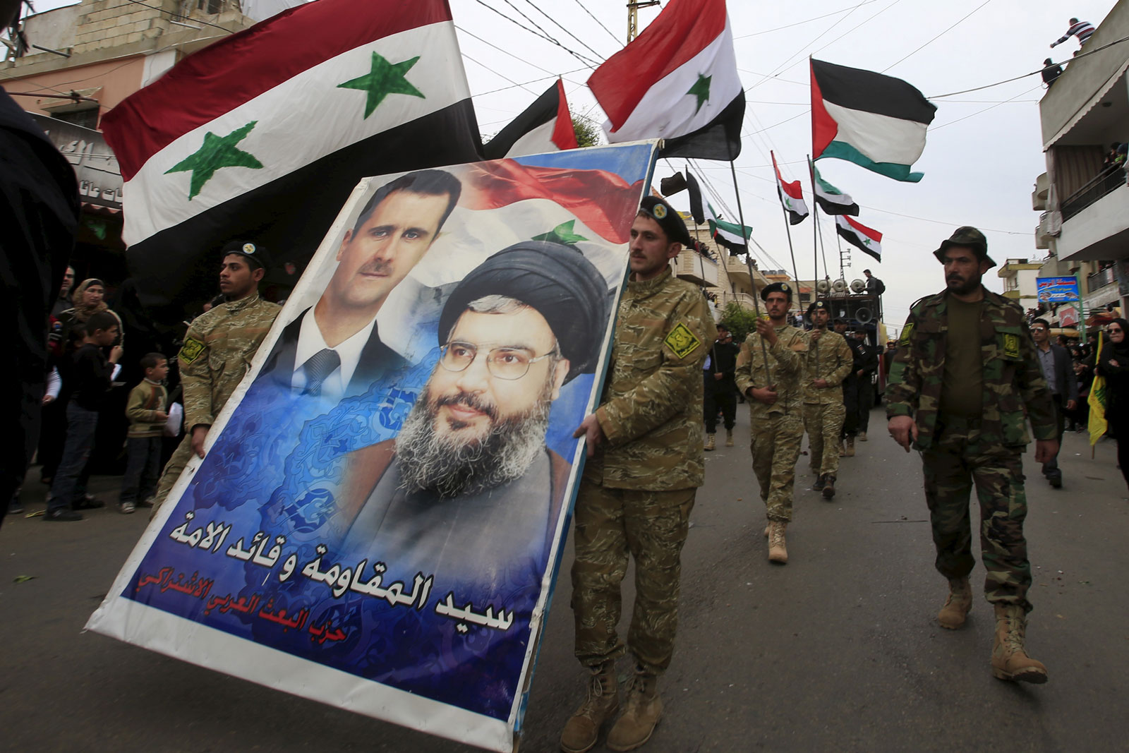 Members of the Arab Socialist Baath Party carry a picture depicting Syria's President Bashar al-Assad and Hezbollah leader Sayyed Hassan Nasrallah, Ansar village, Lebanon, March 2, 2016