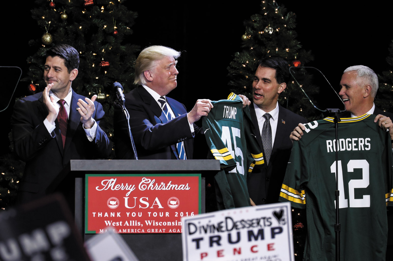 President-Elect Donald Trump holding a Green Bay Packers jersey during his ‘Thank You Tour,’ West Allis, Wisconsin, December 2016. With him are House Speaker Paul Ryan, Wisconsin Governor Scott Walker, and Vice President–Elect Mike Pence.