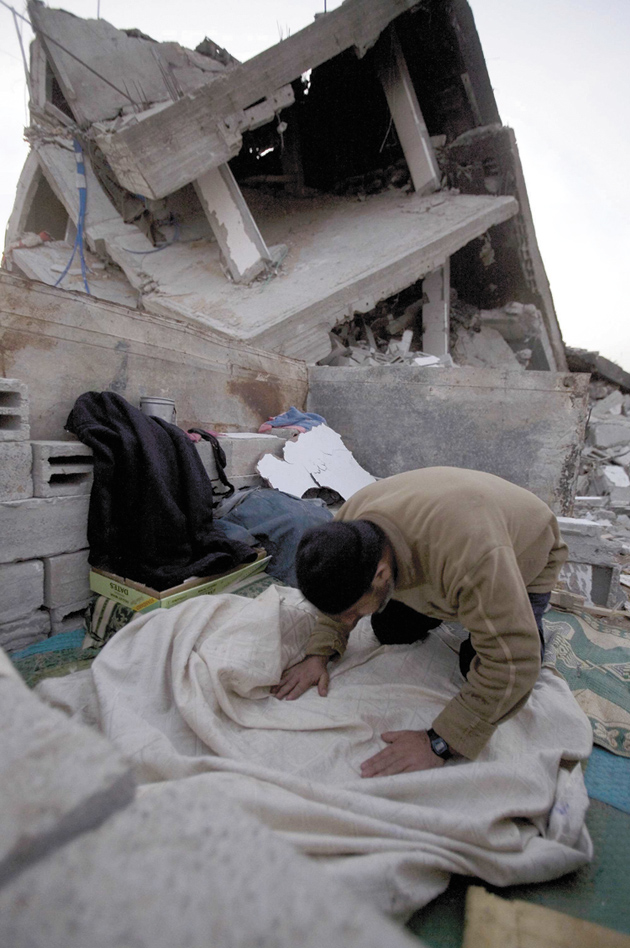 A Palestinian praying by the ruins of his house, Jabalya, Gaza, January 26, 2009
