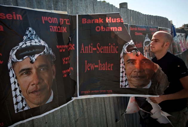 An Israeli man tearing anti-Obama posters hung by an extremist right-wing group, Jerusalem, June 14, 2009