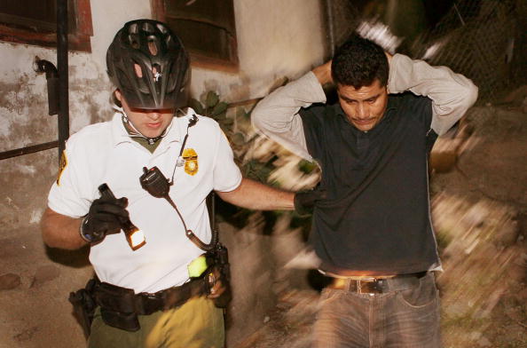 A US Customs and Border Protection agent apprehending an undocumented immigrant after he was spotted entering the country illegally, Nogales, Arizona, June 2, 2010