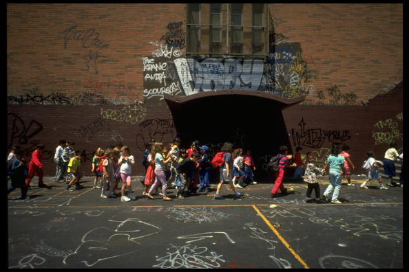 Students in graffiti-filled yard at a public school in East Harlem, May 1991