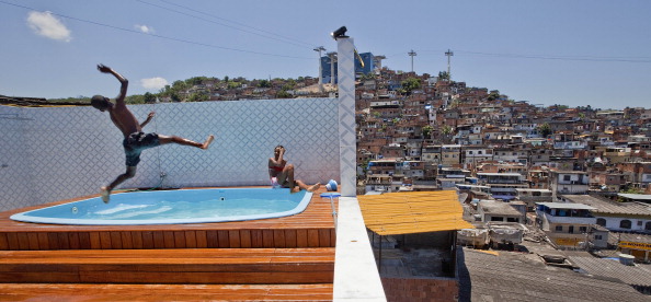 Children playing in a pool after a police raid on the house of the chief drug dealer of the Morro do Alemao favela, Rio de Janeiro, November 28, 2010