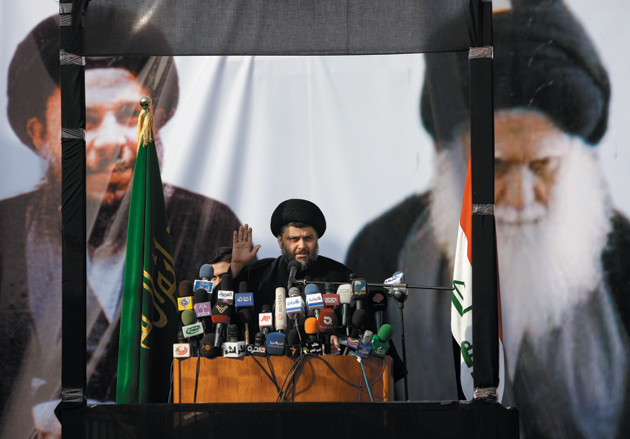 The Iraqi Shiite cleric Moqtada al-Sadr giving a speech in Najaf during his first public appearance in Iraq after four years in exile in the Iranian city of Qom, January 8, 2011. Pictured on the banner behind him are his father-in-law, the late Grand Ayatollah Mohammed Baqir al-Sadr, founder of the Islamic Dawa Party, and his father, the late Grand Ayatollah Mohammed Sadiq al-Sadr. These two men are seen as the spiritual forebears of the Sadrist movement that Moqtada al-Sadr heads.