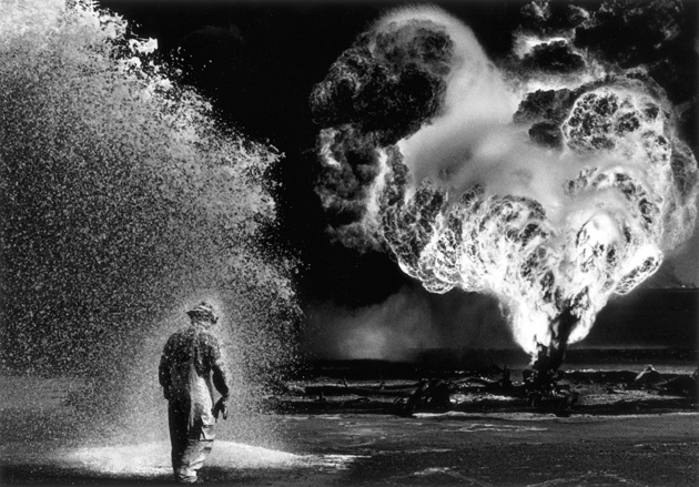 A firefighter under a protective chemical spray at Kuwait’s Greater Burhan Oil Field, which retreating Iraqi troops had set on fire, 1991; photograph by Sebastião Salgado
