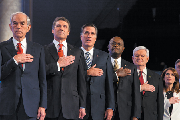 Republican presidential candidates Ron Paul, Rick Perry, Mitt Romney, Herman Cain, Newt Gingrich, and Michele Bachmann during the National Anthem before a debate, Washington, D.C., November 22, 2011
