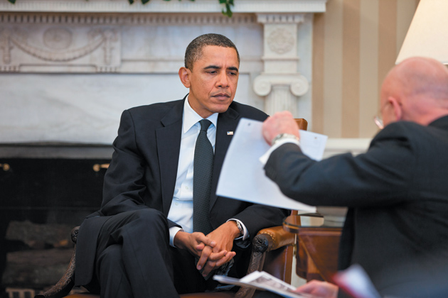 President Barack Obama studying a document held by Director of National Intelligence James Clapper during the presidential daily briefing in the Oval Office, February 3, 2011
