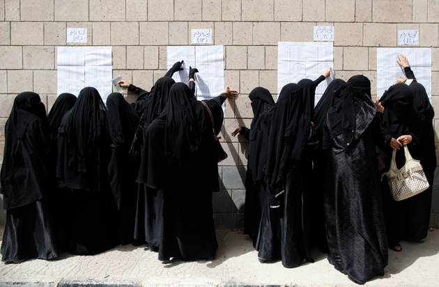 Yemeni women looking for their names on a registration list before voting in the presidential election that ended the thirty-three-year rule of Ali Abdullah Saleh, Sanaa, February 21, 2012
