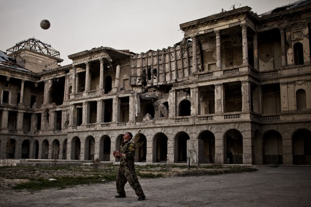 A young Afghan National Army soldier playing volleyball on the grounds of the battle-scarred Darulaman Palace outside Kabul, March 23, 2012. The former king's residence, the palace was destroyed in the 1990s during heavy fighting in Afghanistan's civil war.