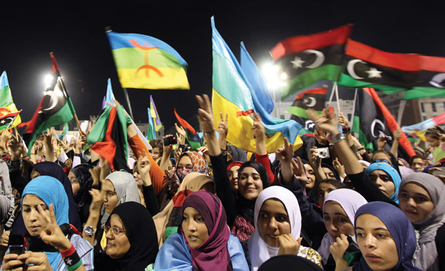 Libyan women waving the new Libyan flag (right) and the flag of the Amazigh people—often called Berbers—during an Amazigh festival in Tripoli, September 27, 2011. The indigenous Amazigh people are asking that a new Libyan constitution include official recognition of their language and culture, which had been prohibited by Muammar Qaddafi.
