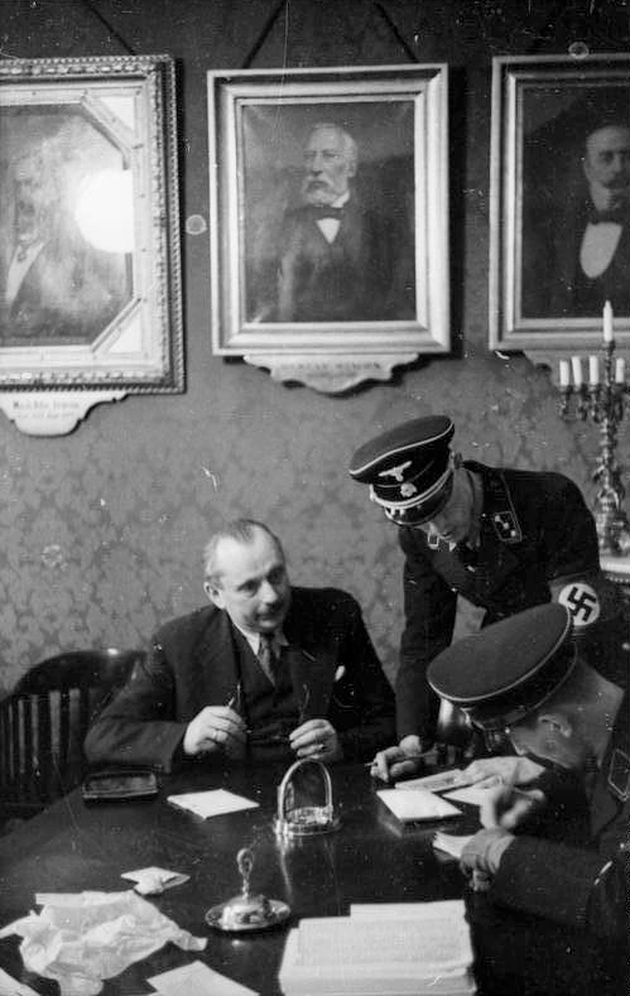 Josef Löwenherz, head of the Israelitische Kultusgemeinde (IKG), Vienna’s Jewish community organization, with SS officers at the IKG offices, March 18, 1938
