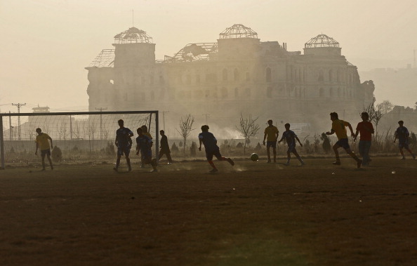Afghan youth playing soccer in front of the ruins of the Dar ul-Aman Palace, Kabul, 2010