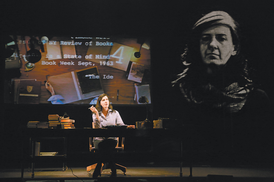 Moe Angelos as the young Susan Sontag in the play Sontag: Reborn, with an image of Angelos as an older Sontag at right, projected onto the scrim in front of the stage