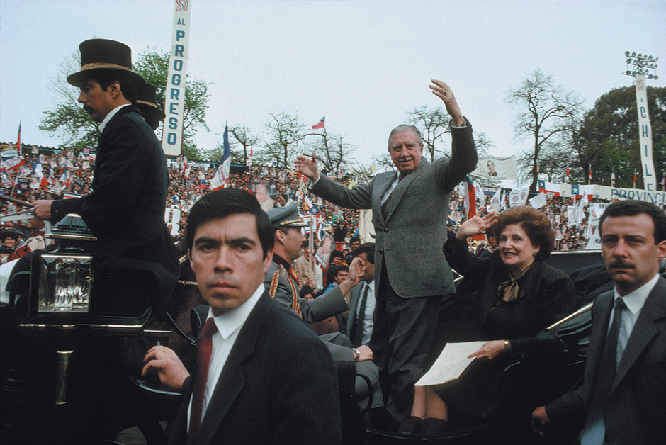 Augusto Pinochet and his wife, Lucía, being paraded around a stadium in a carriage, Talca, Chile, 1988