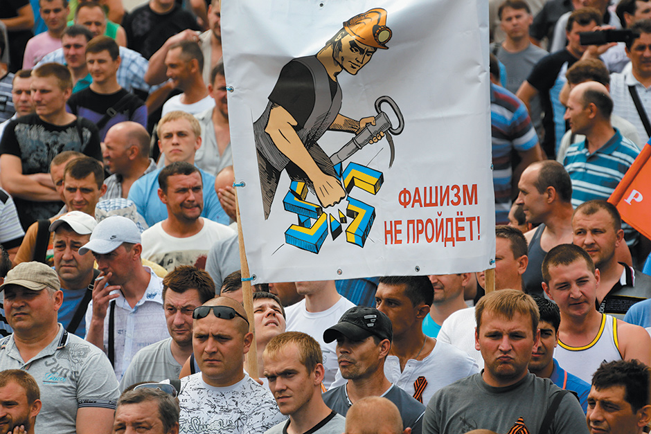 Local miners at a rally in support of the Donetsk People’s Republic with a banner showing a miner smashing a swastika in the color of Ukraine’s flag, May 28, 2014