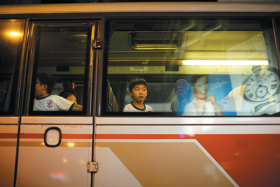 A boy watching pro-democracy demonstrators from a school bus near a protest site in Hong Kong, October 2014