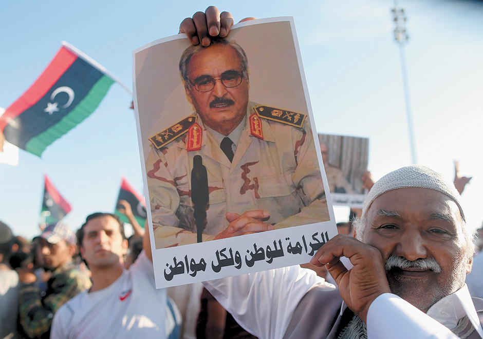 A supporter of the anti-Islamist campaign Operation Dignity holding a picture of its leader, General Khalifa Haftar, at a demonstration in Benghazi, Libya, May 2014