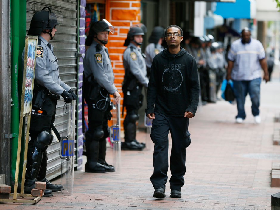 Police officers watching pedestrians in Baltimore, Maryland, following the death of Freddie Gray, May 2, 2015