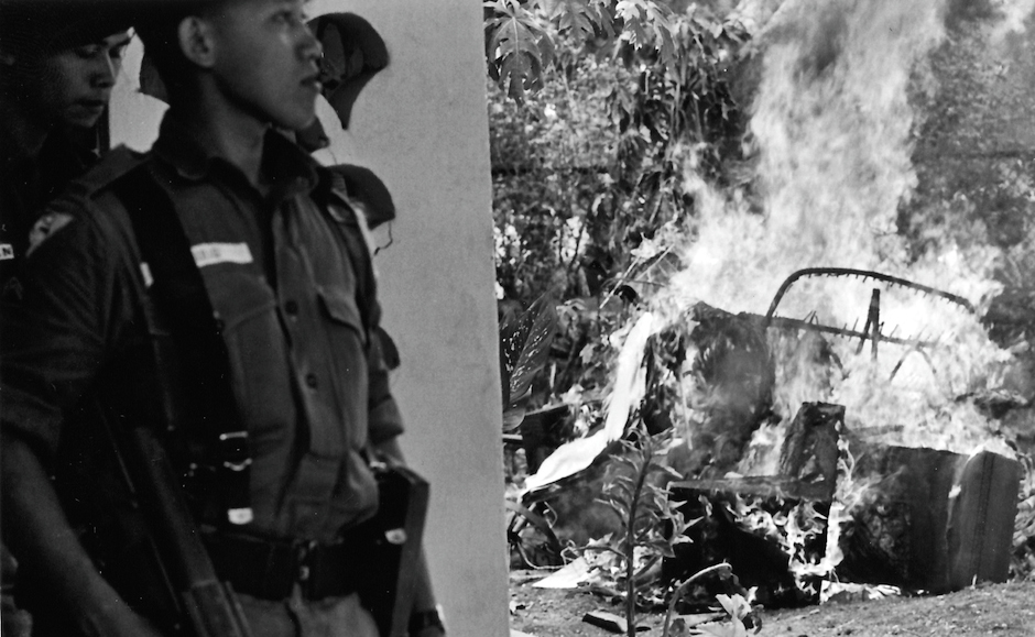 Indonesian soldiers near the burning wreckage of a vehicle, following the assassination of six army generals, Jakarta, October 1965