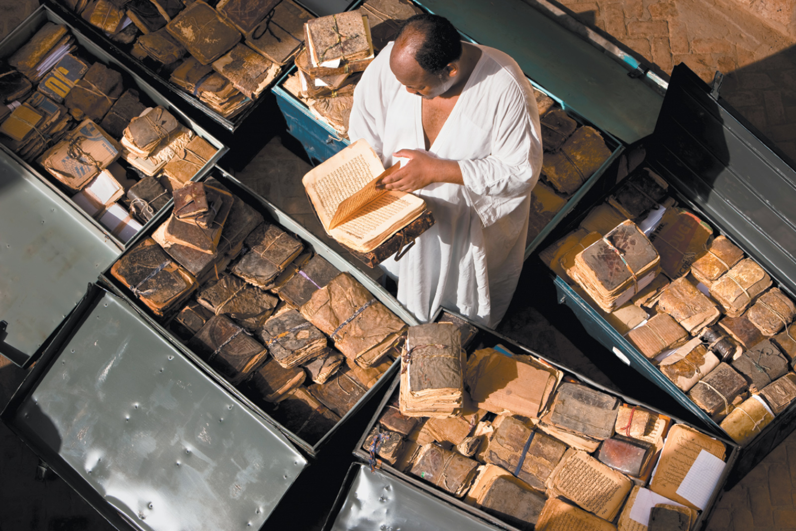 Abdel Kader Haidara in Timbuktu with ancient manuscripts from Mali, Niger, Ethiopia, Sudan, and Nigeria, September 2009. Haider was instrumental in saving the manuscripts during the militant Islamist takeover of Timbuktu in 2012.
