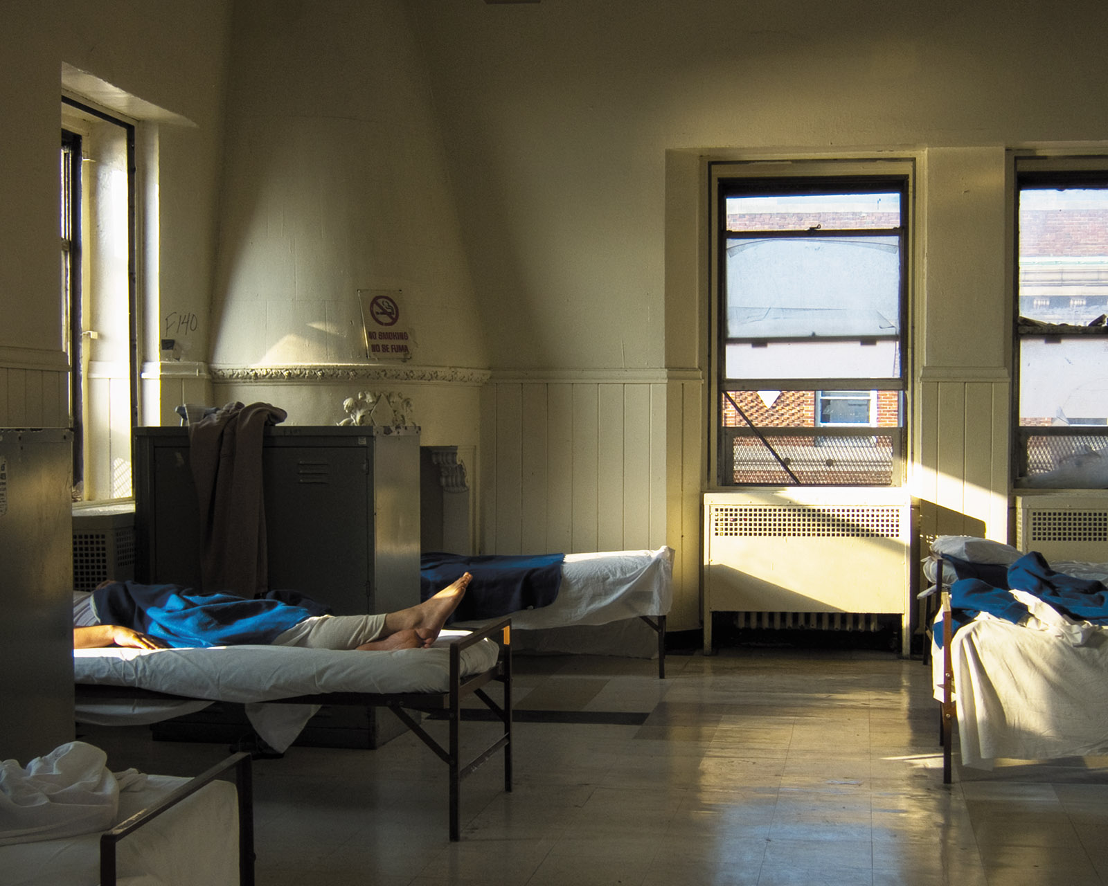 A shared room at the Bellevue Men’s Shelter, housed since 1984 in the former psychiatric building of Bellevue Hospital, New York City, 2010; photograph by Eric Michael Johnson