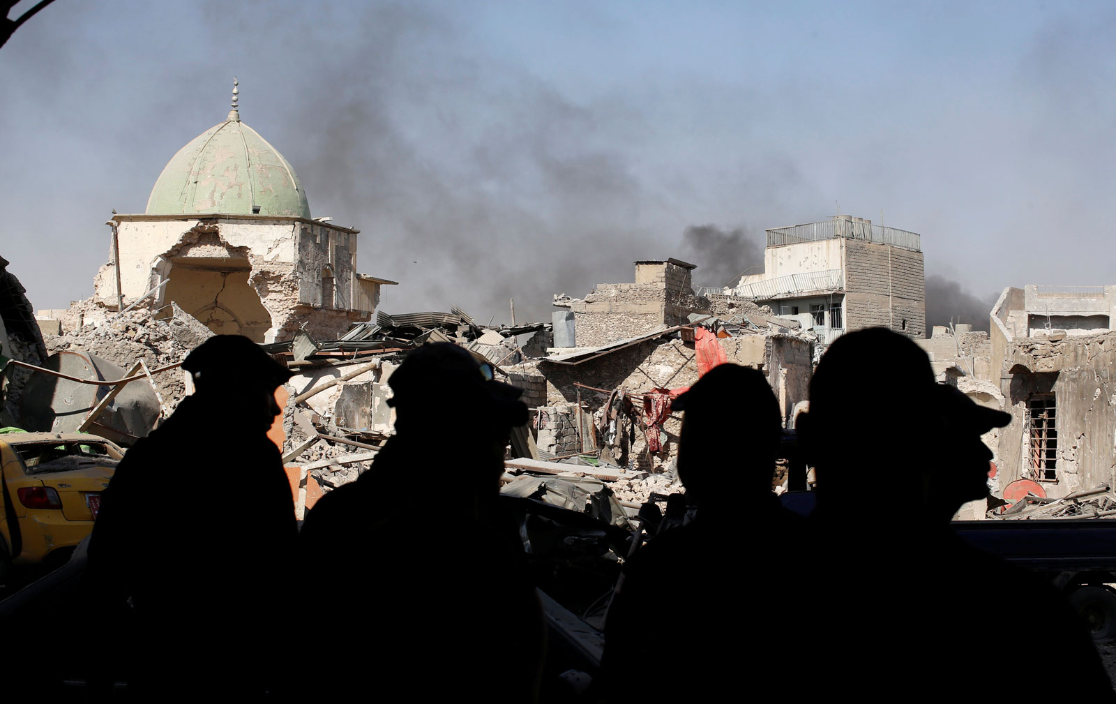 Members of Iraqi Counter Terrorism Service and the media standing before the ruins of the Grand al-Nuri Mosque, Mosul, June 29, 2017