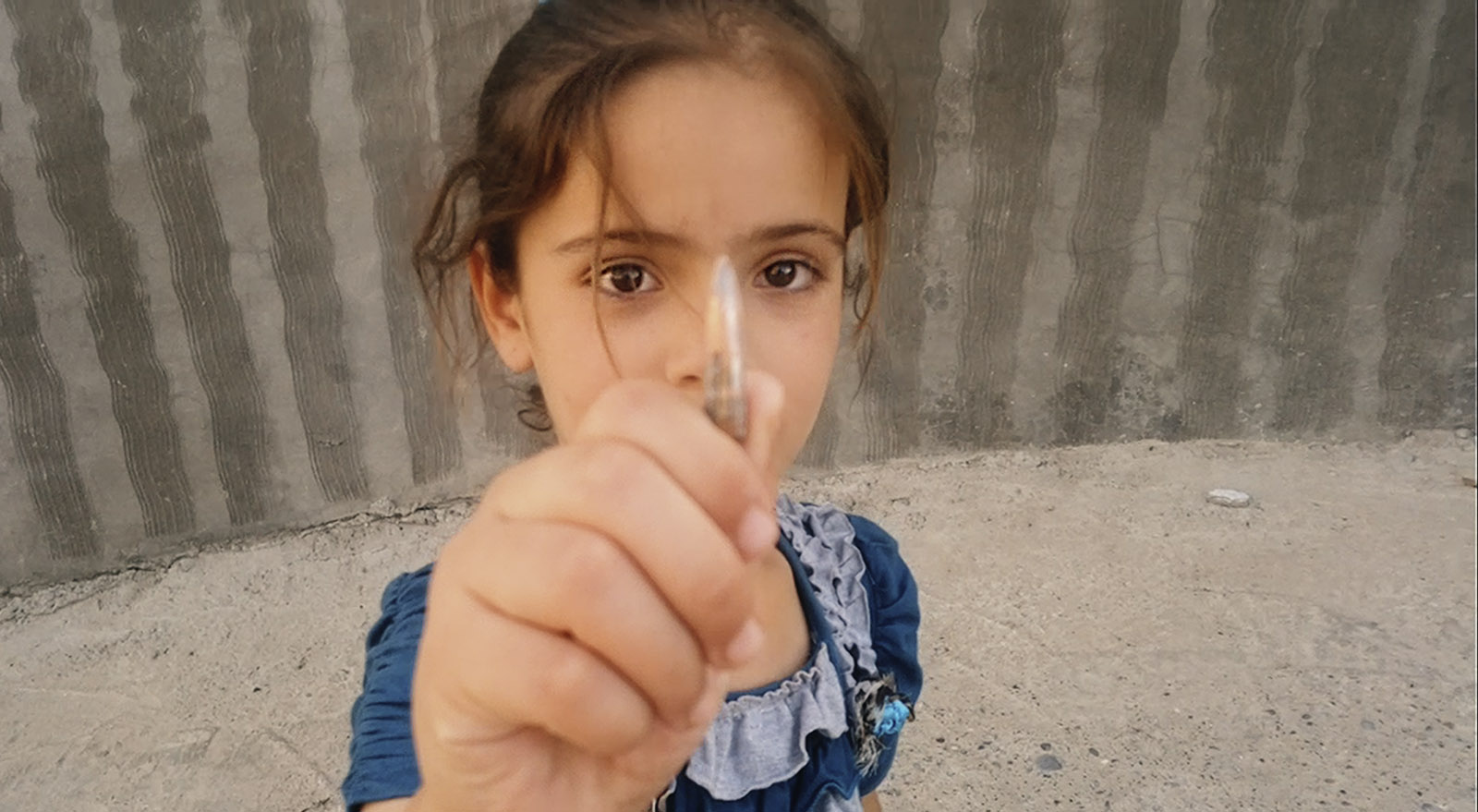 Nori Sharif's daughter, Sarah, holding a bullet