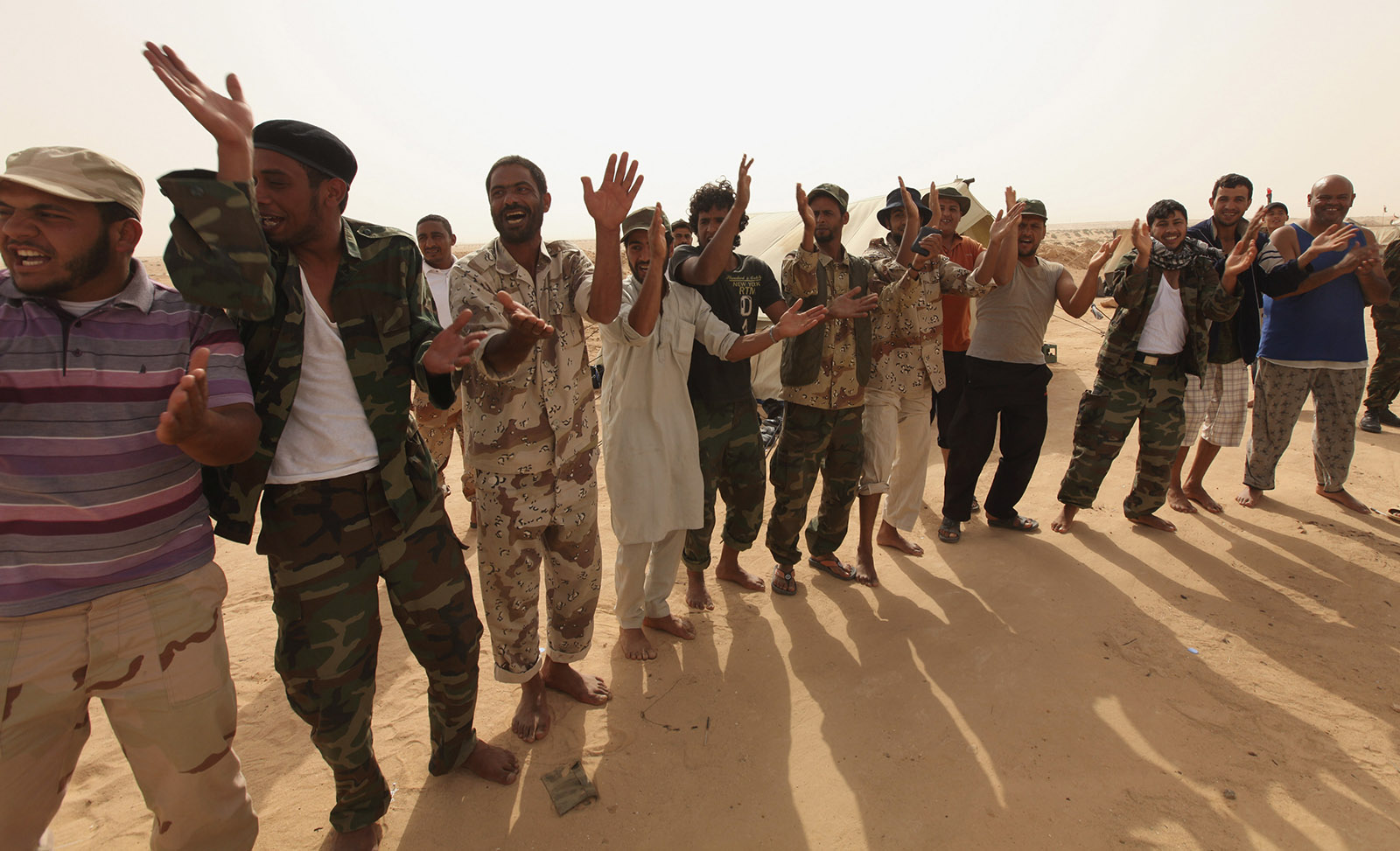Rebel fighters celebrate on the front line, after hearing news that the ICC had issued an arrest warrant for Libyan leader Gaddafi