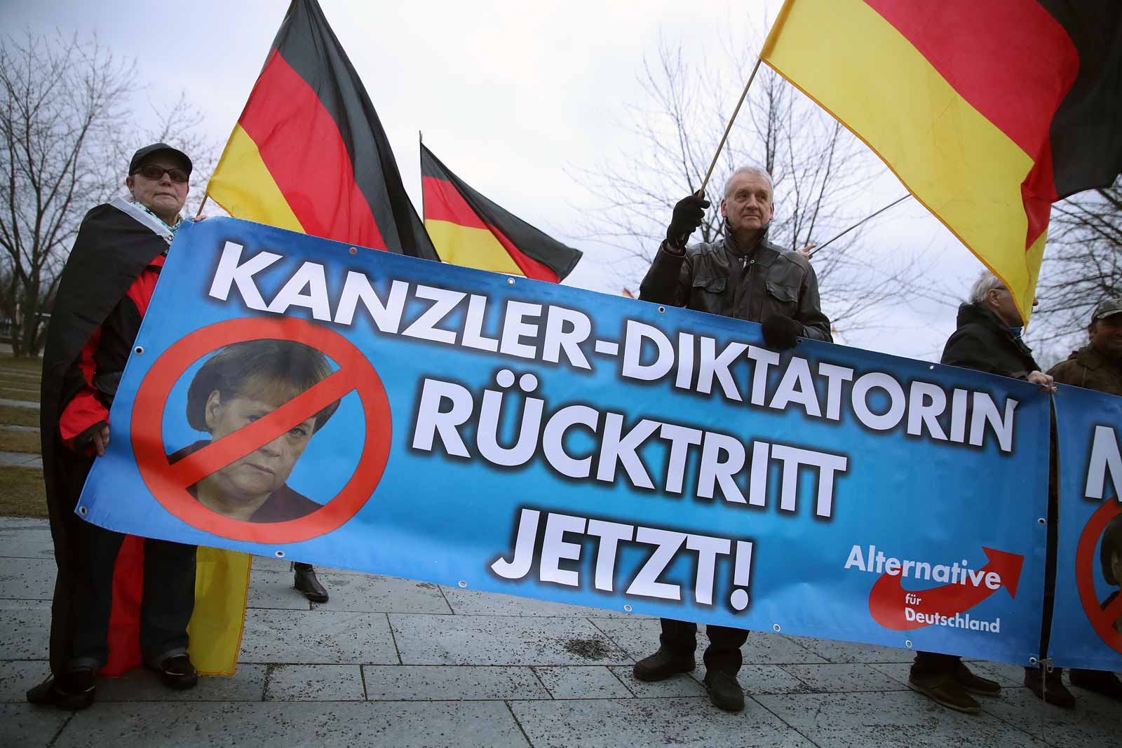 Supporters of Germany's far-right AfD party holding a banner that reads, 