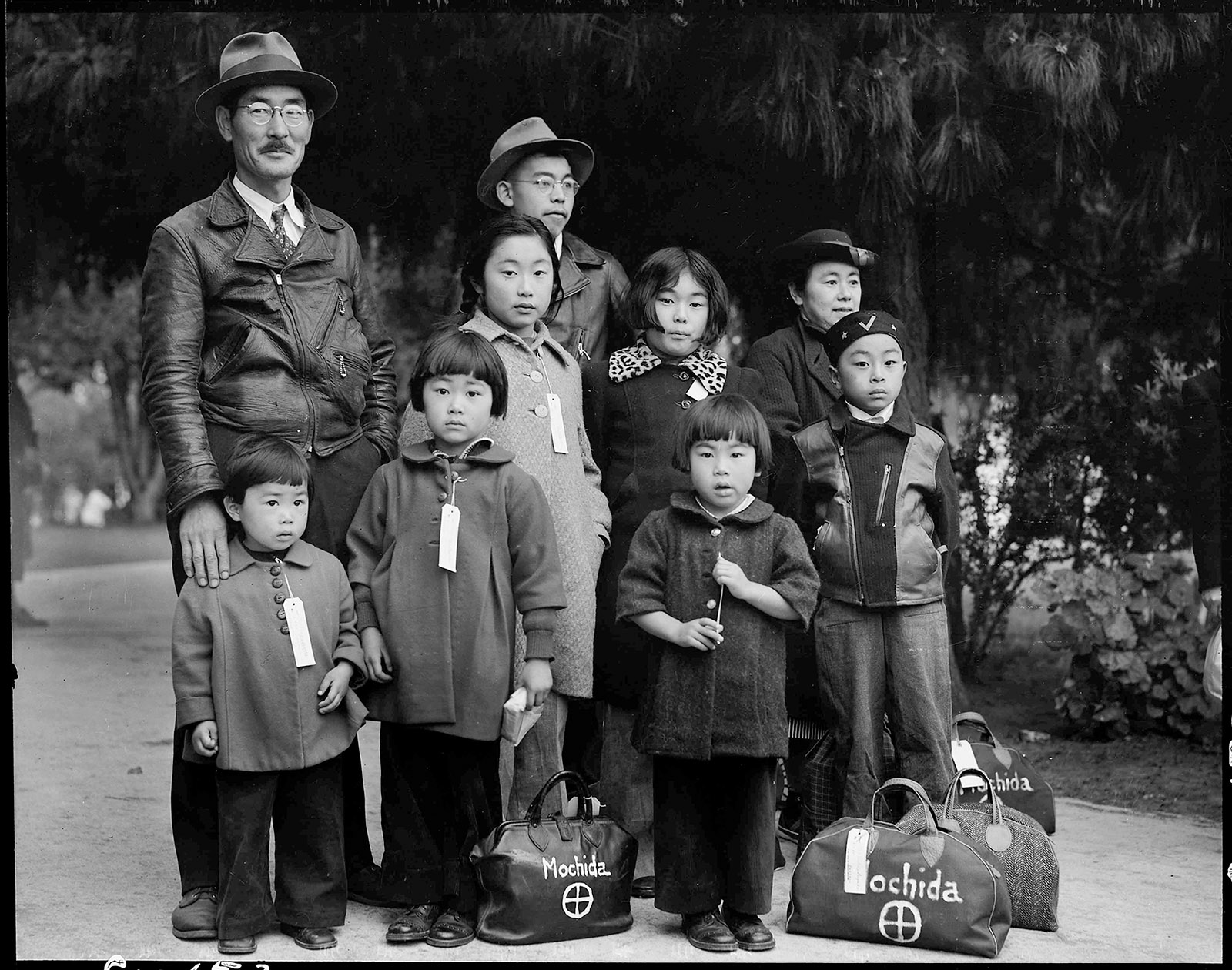 ‘Members of the Mochida family awaiting evacuation bus,’ Hayward, California, May 1942; photograph by Dorothea Lange. It is on view in the exhibition ‘Then They Came for Me: Incarceration of Japanese Americans During World War II,’ at the International Center of Photography, New York City, January 26–May 6, 2018.