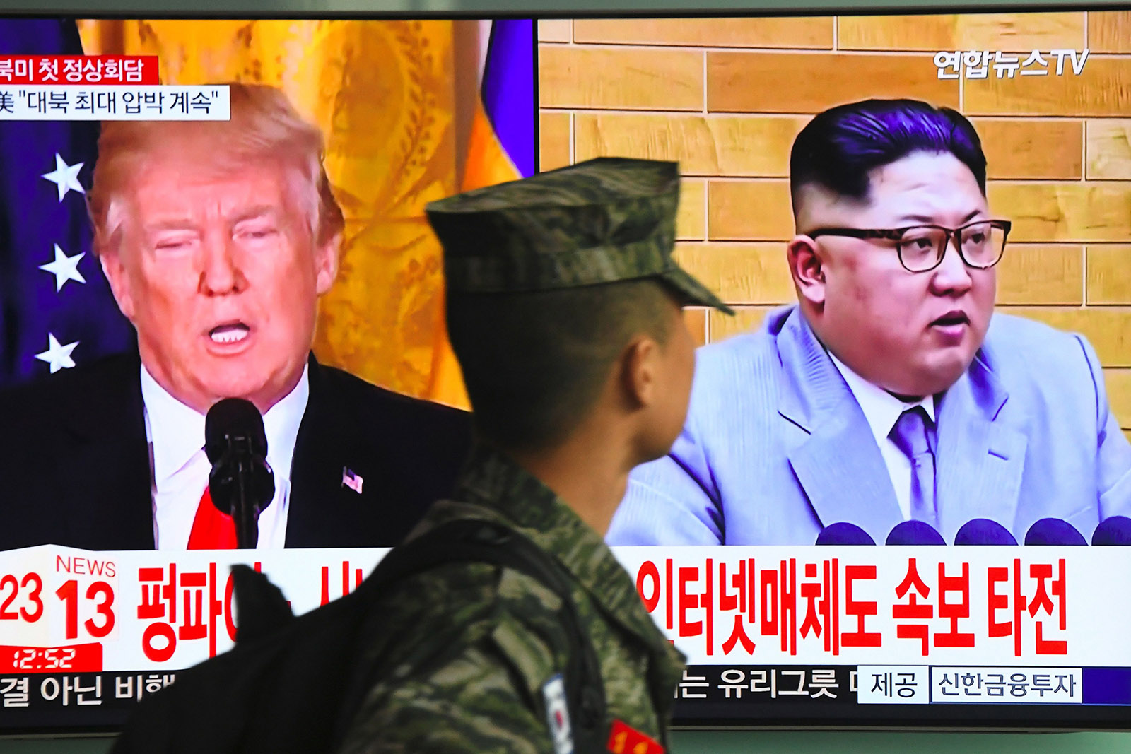 A South Korean soldier passing giant TV screen images of US President Donald Trump and North Korean leader Kim Jong-un in Seoul, South Korea, on March 9, 2018