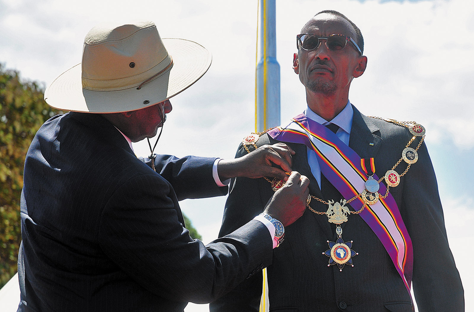 Rwandan president Paul Kagame receiving the Pearl of Africa Medal from Ugandan president Yoweri Museveni, Kapchorwa District, Uganda, 2012