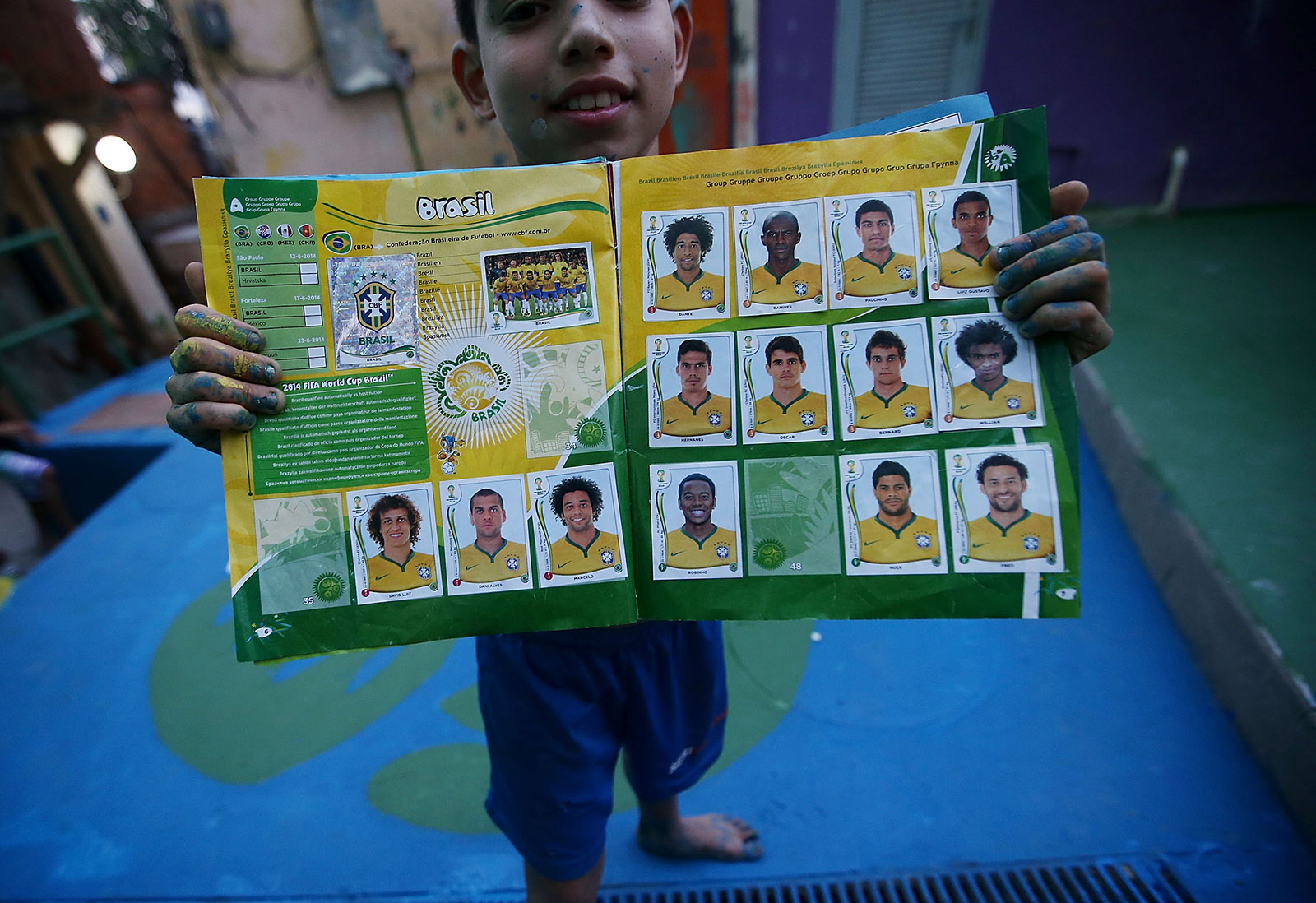 A boy from Santa Marta favela with his Panini World Cup sticker book, Rio de Janeiro, Brazil, 2014