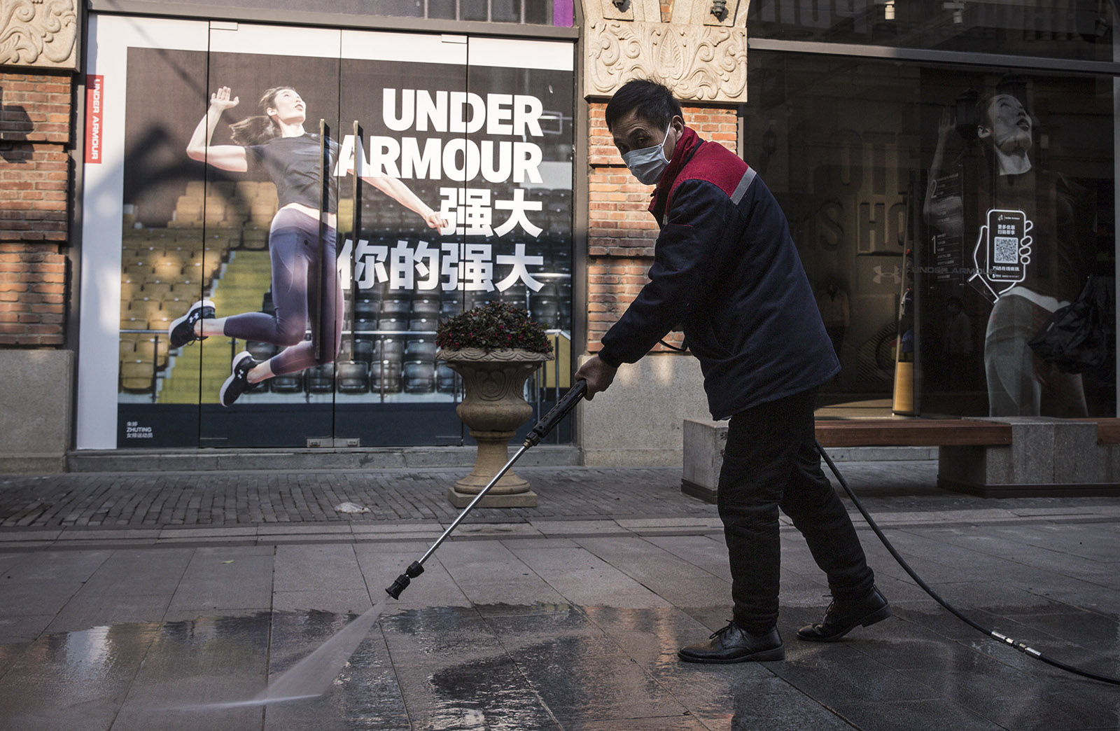 A street-cleaner working in a virtually deserted shopping precinct during the coronavirus lockdown of Wuhan, Hubei province, China, February 3, 2020
