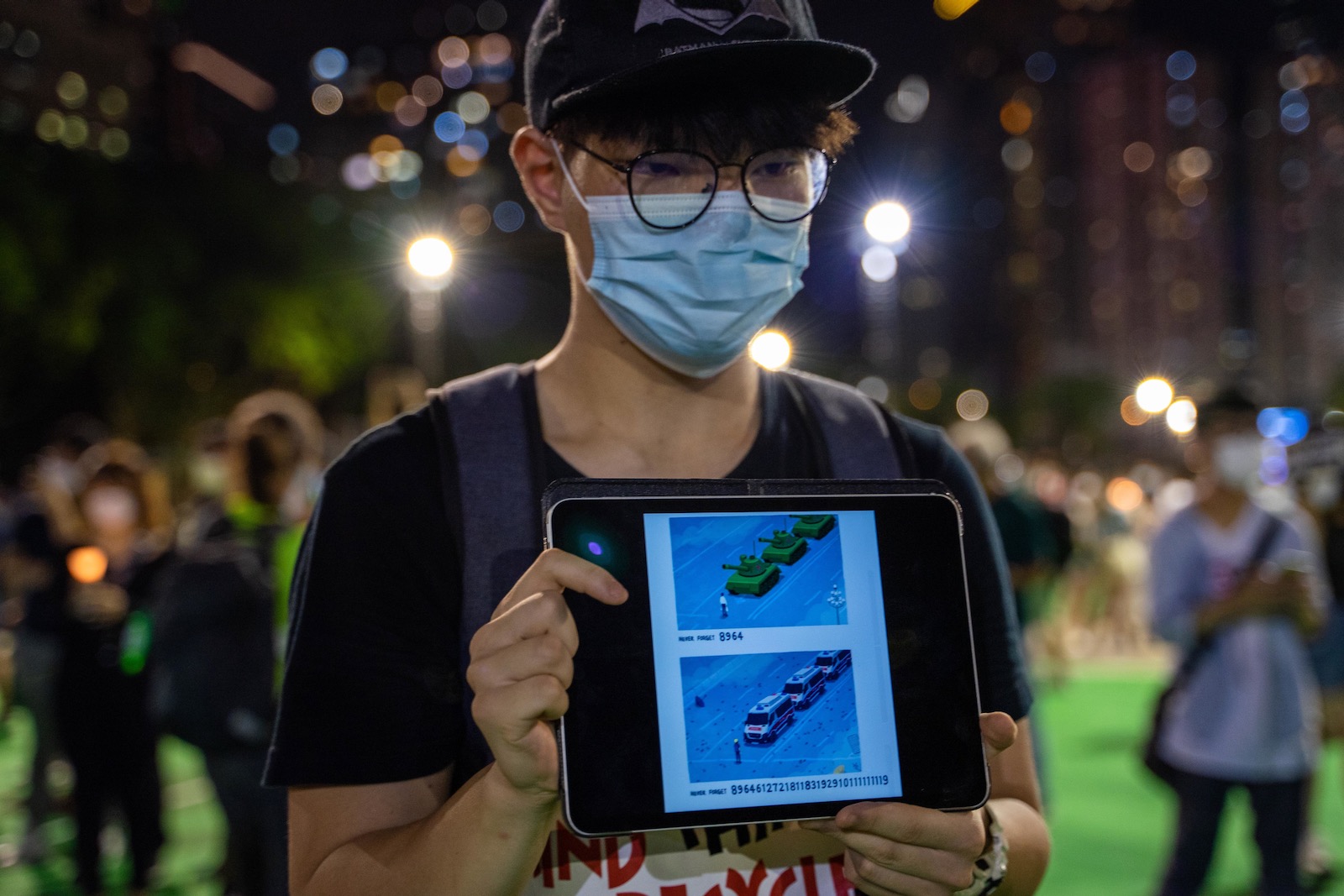 A participant displaying images on a tablet device at a vigil in Victoria Park linking pro-democracy protests with the 1989 Tiananmen Square in China, Hong Kong, June 4, 2020