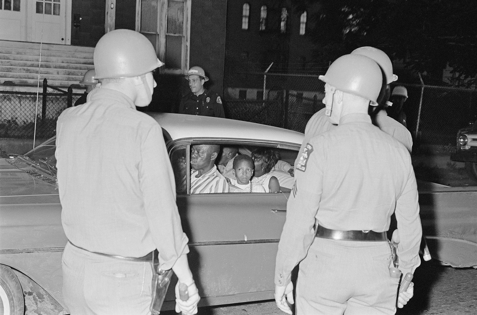 New York State Police officers stopping a black family during the Rochester race riot, July 1964