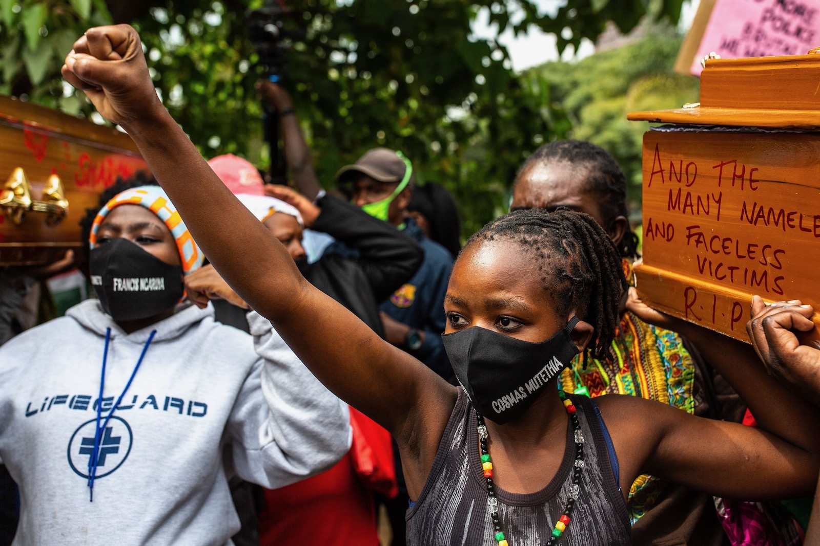 The widow of Cosmas Mutethia, who was killed by Kenyan police during a night curfew, helping to bear a symbolic coffin at a protest outside the Kenyan Parliament, Nairobi, Kenya, June 9, 2020