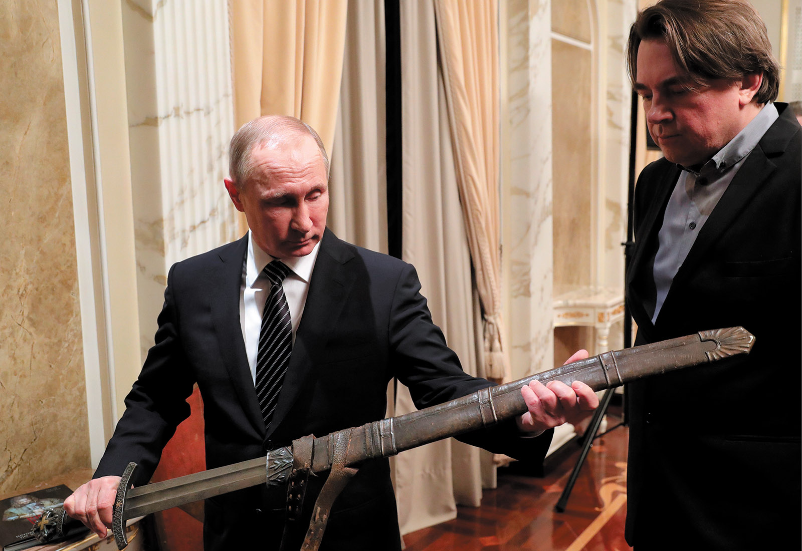 Vladimir Putin and Konstantin Ernst admiring a replica sword from a film produced by Ernst