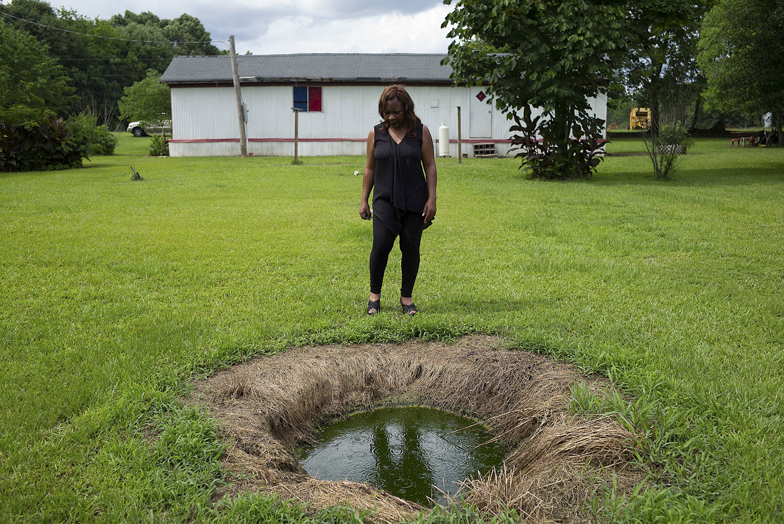 Catherine Coleman Flowers standing over a pool of raw sewage outside a house in White Hall, Alabama