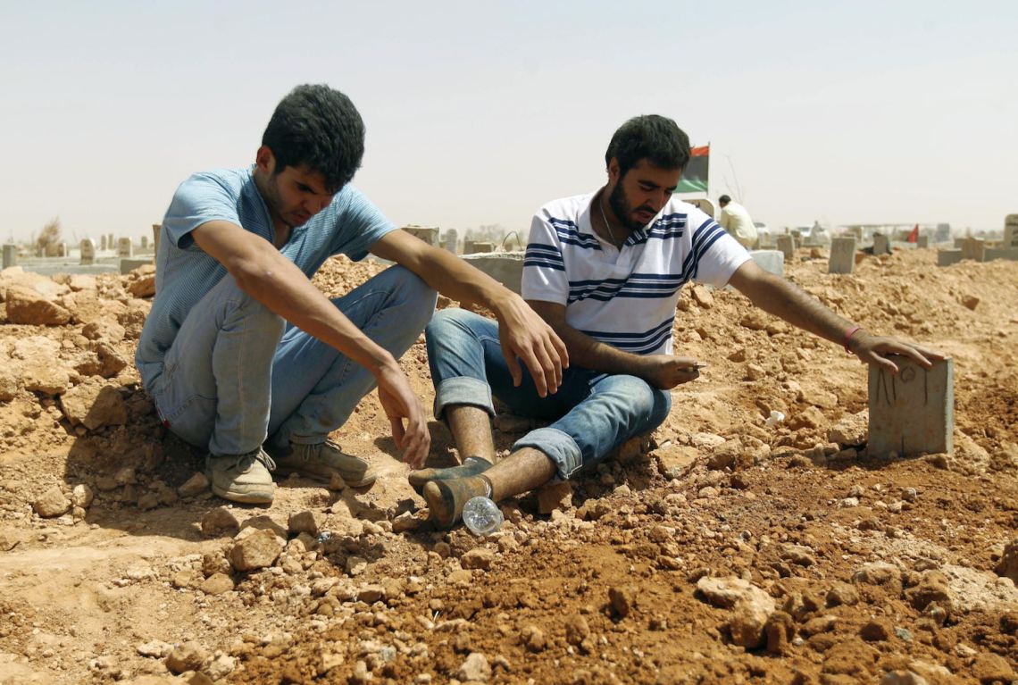 Libyans mourning beside a grave