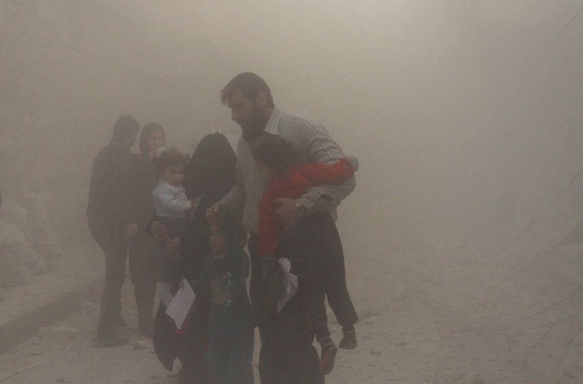 Civilians emerging from destruction caused in a bombing attack