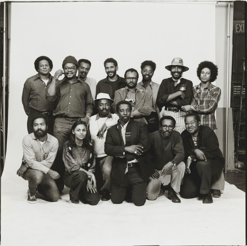Fourteen members of Kamoinge pose together for a group portrait