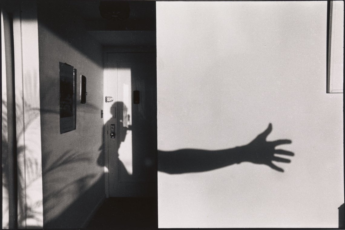 The shadow of the photographer's body and outstretched hand on a sunlit wall